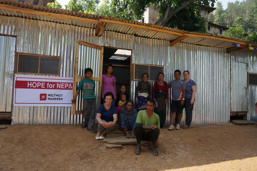Sandra, Ihre Familie und Team vor einer der neuerrichteten Hütten